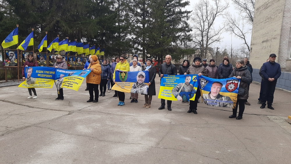 Люди стогять з плакатами зниклих безвісти та полонених воїнів