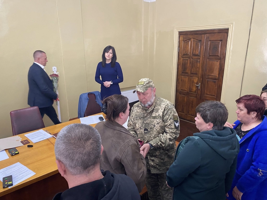 Військовий вручає рідним нагороду загиблого воїна