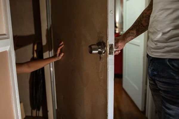 Чоловік відкриває двері за якими видно дитину, атмосфера ворожості