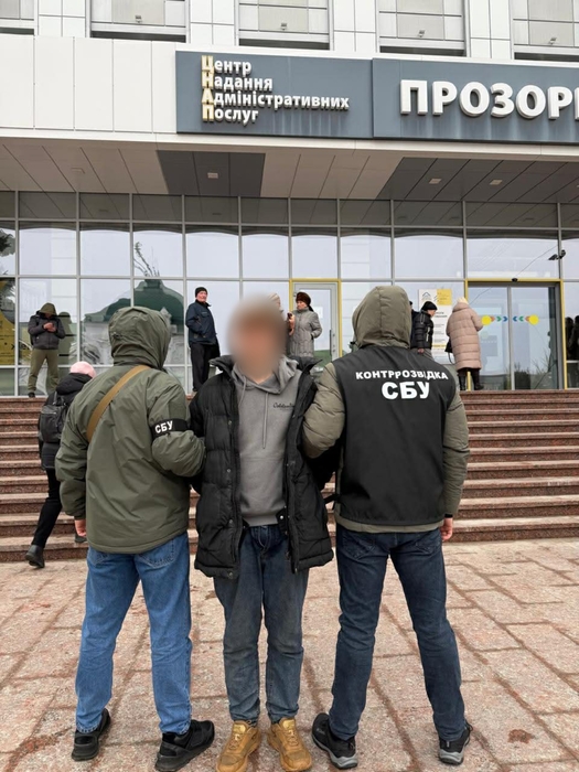 Працівники СБУ тримають затриманого підозрюваного біля будівлі ЦНАПу в Кропивницькому