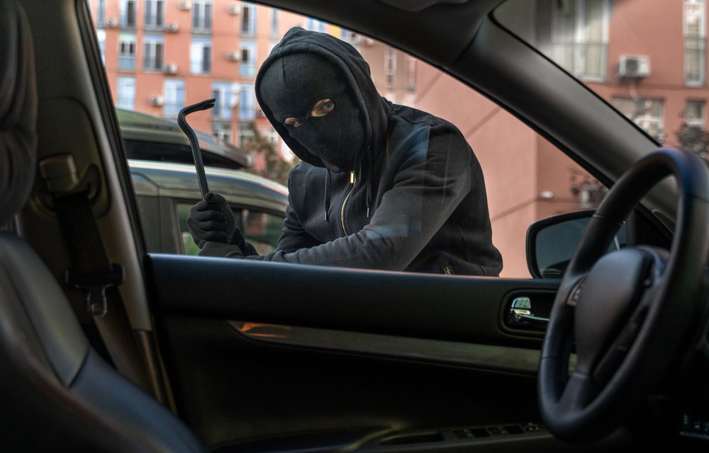 Чоловік намагається розбити вікно автомобіля