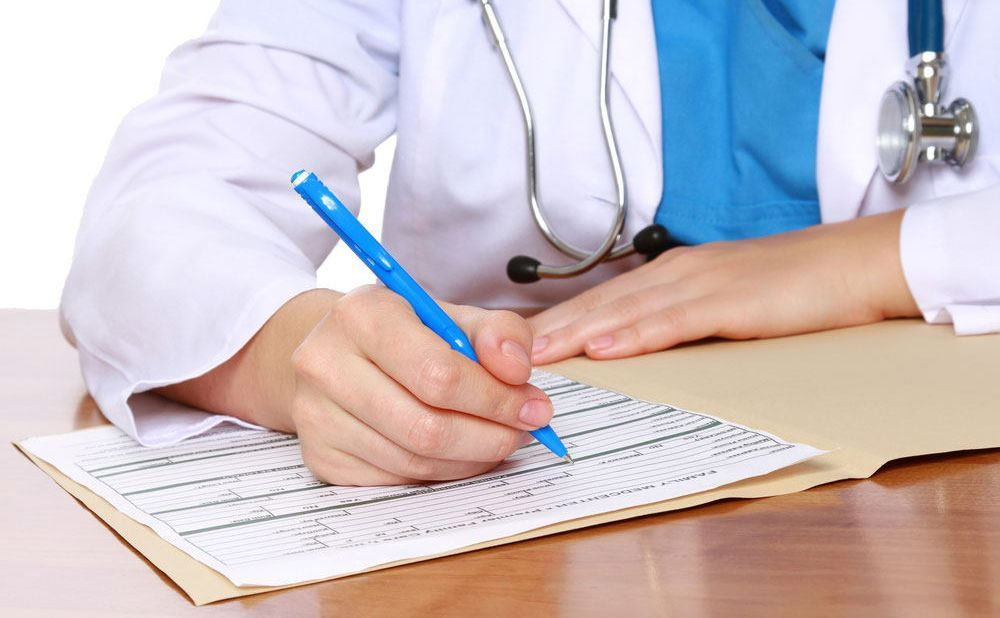 Лікар підписує документи