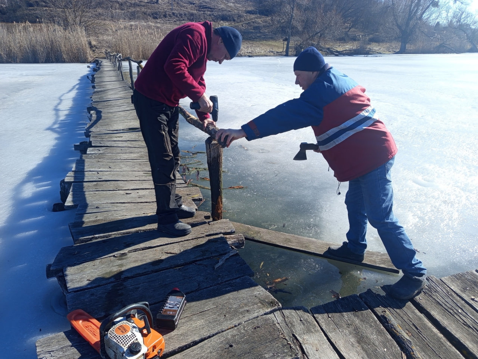 Чоловіки ремонтують дерев'яний міст