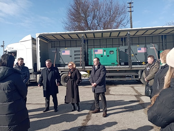 Посадовці стоять біля генераторів від американських партнерів