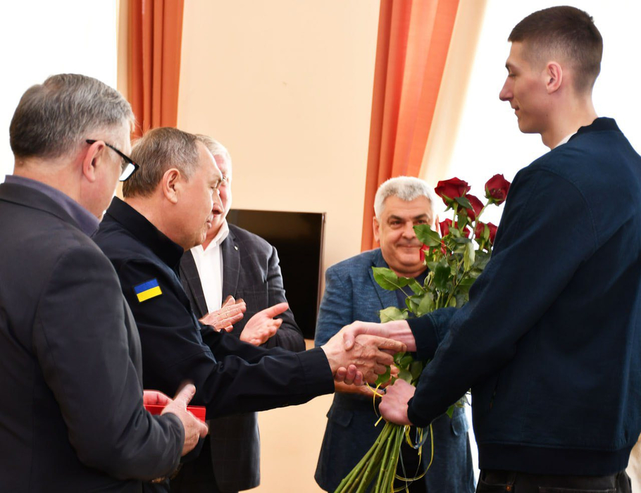 Олег Дорощук приймає нагороду від Андрія Райковича