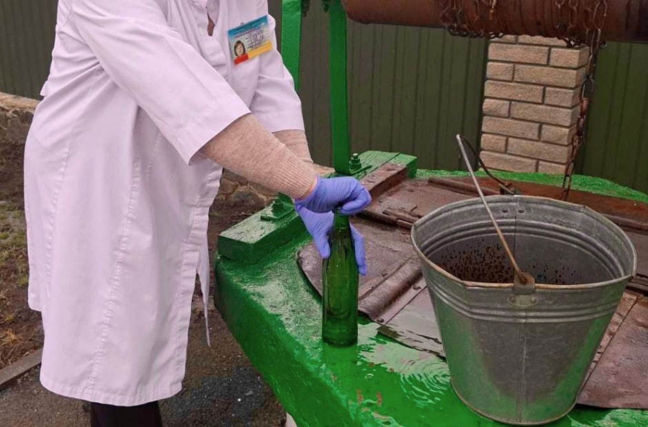 Фахівчиня ЦКПХ бере зразок води з криниці