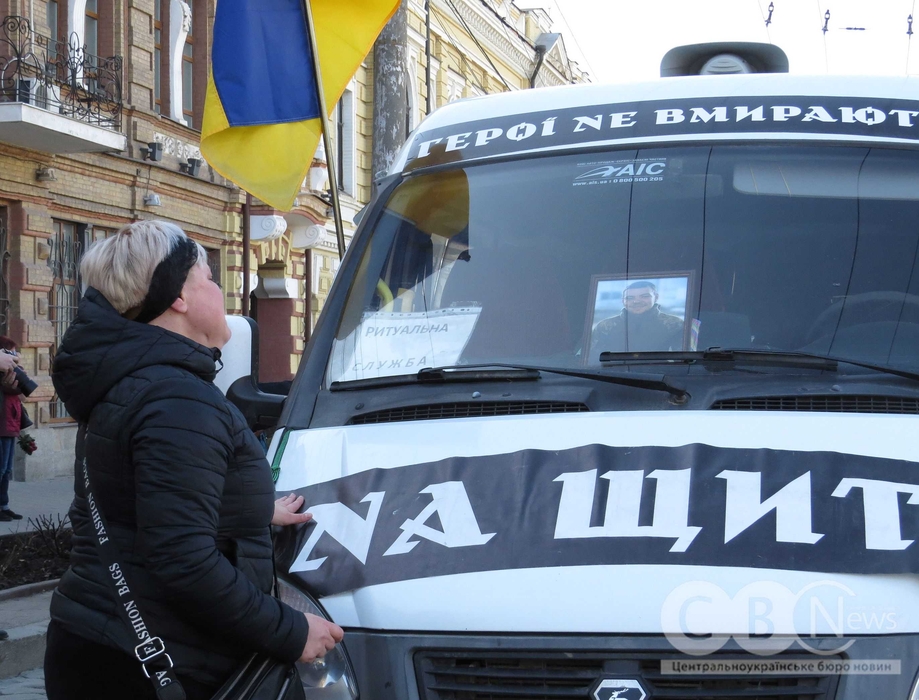 Жінка дивиться на портрет загиблого військового на прощанні у Кропивницькому