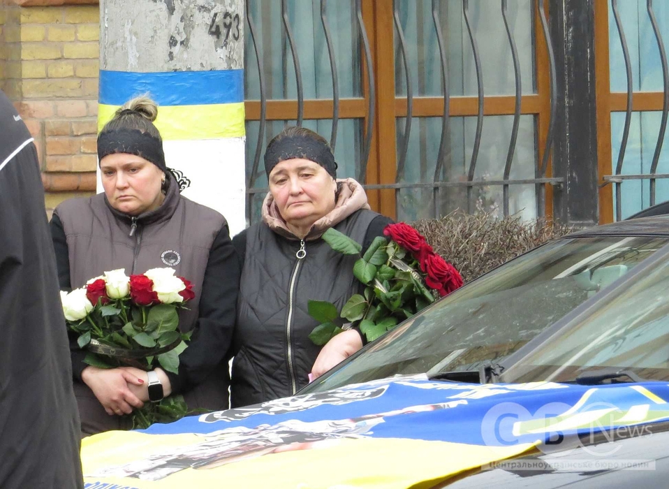 Люди стоять під час хвилини мовчання на прощанні з Григорієм Бобирем та Андрієм Хлусевичем
