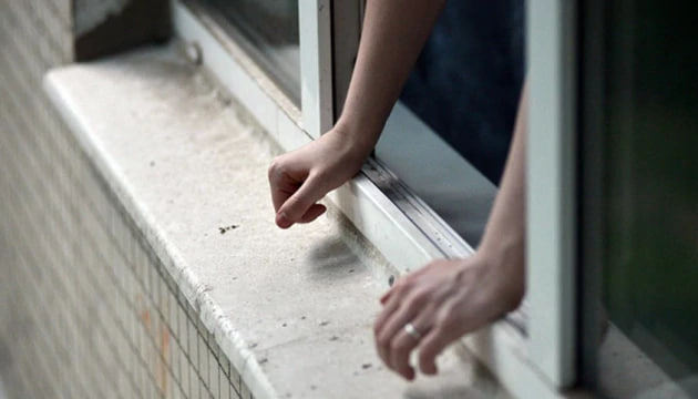 Ілюстративне зображення людських рук, що спираються на відкрите вікно