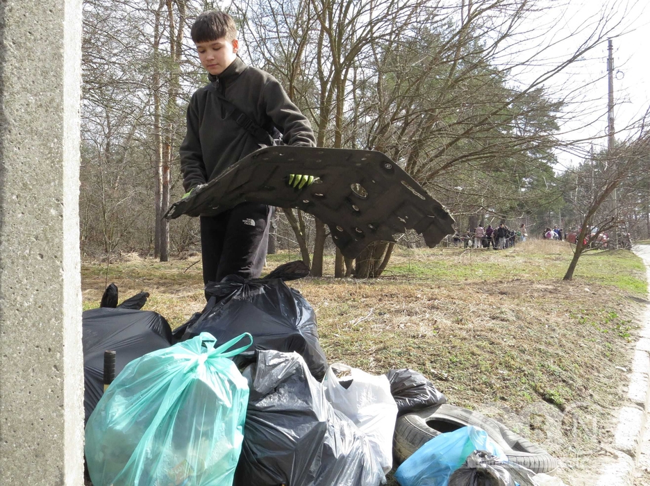 Хлопчик несе в руці сміття