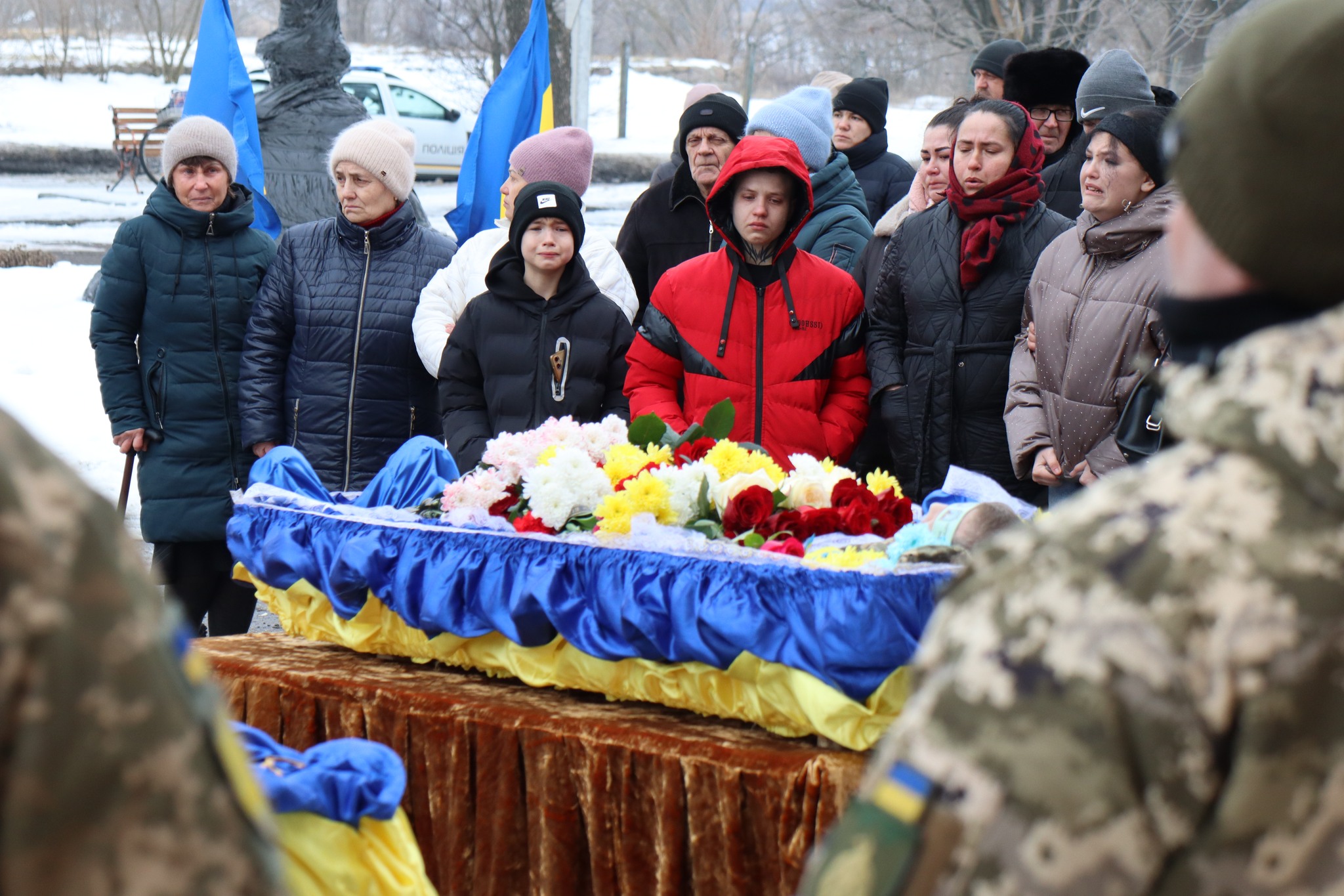 Люди стоять біля труни померлого Миколи Сичова з Онуфріївської громади