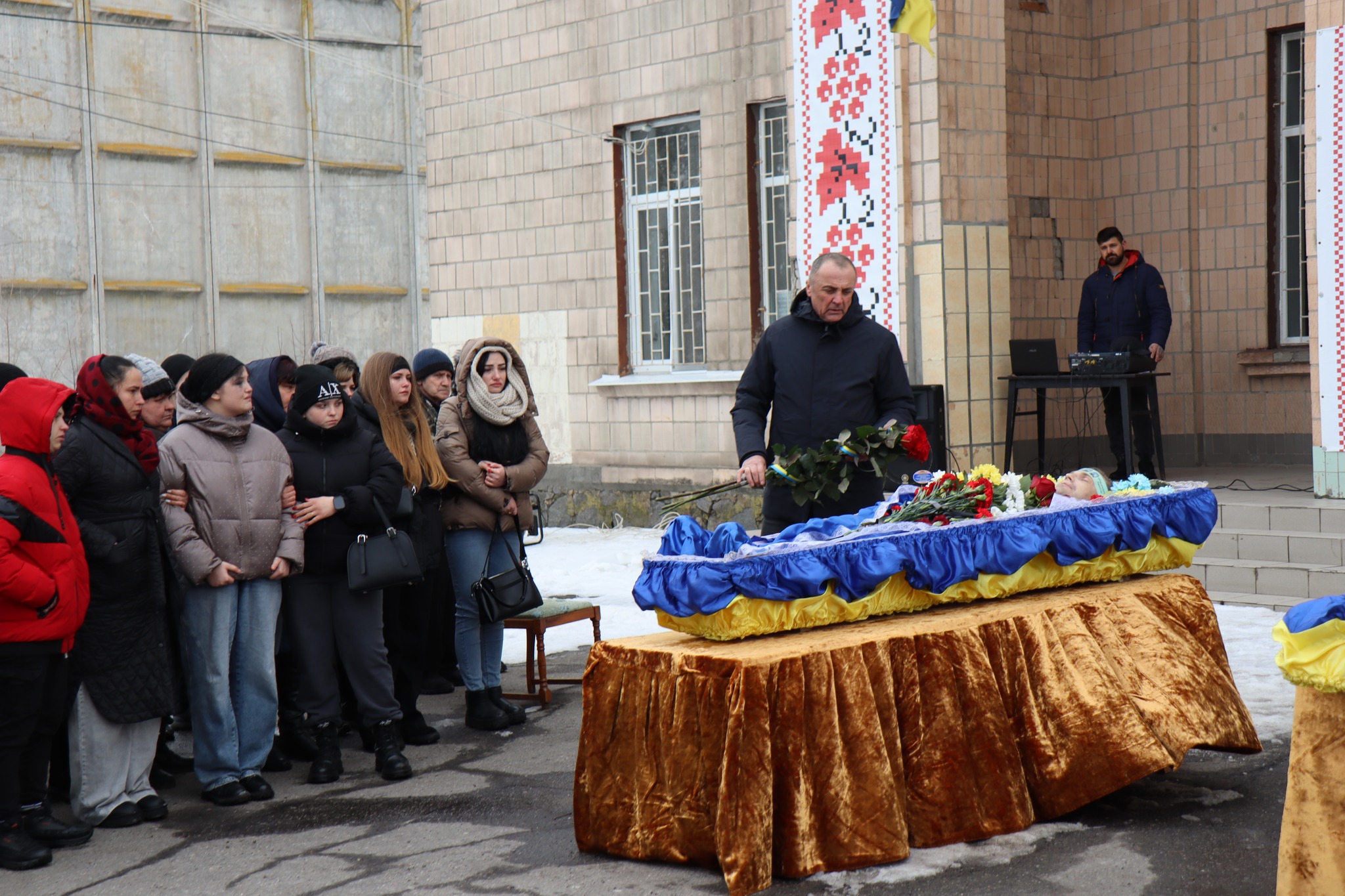 Люди стоять біля труни померлого Миколи Сичова з Онуфріївської громади