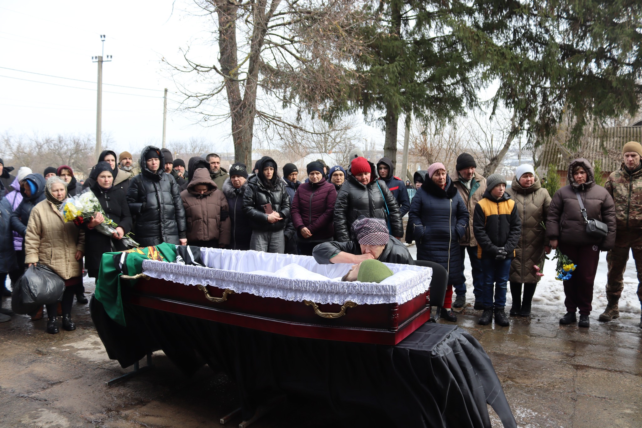 Люди та мати стоять біля труни загиблого Олега Загороднюка з Добровеличківської громади