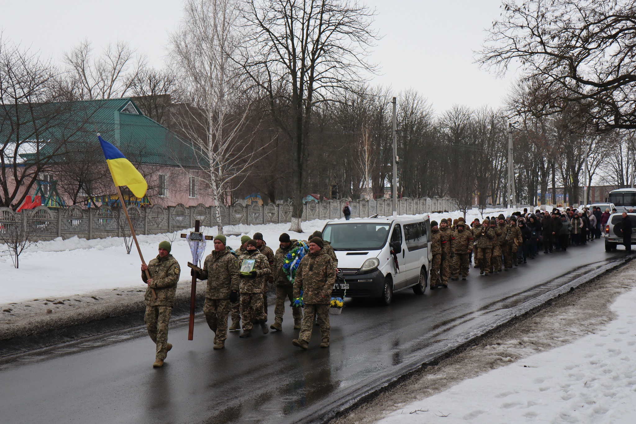 Воїни несуть намогильний хрест померлог Миколи Сичова з Онуфріївської громади