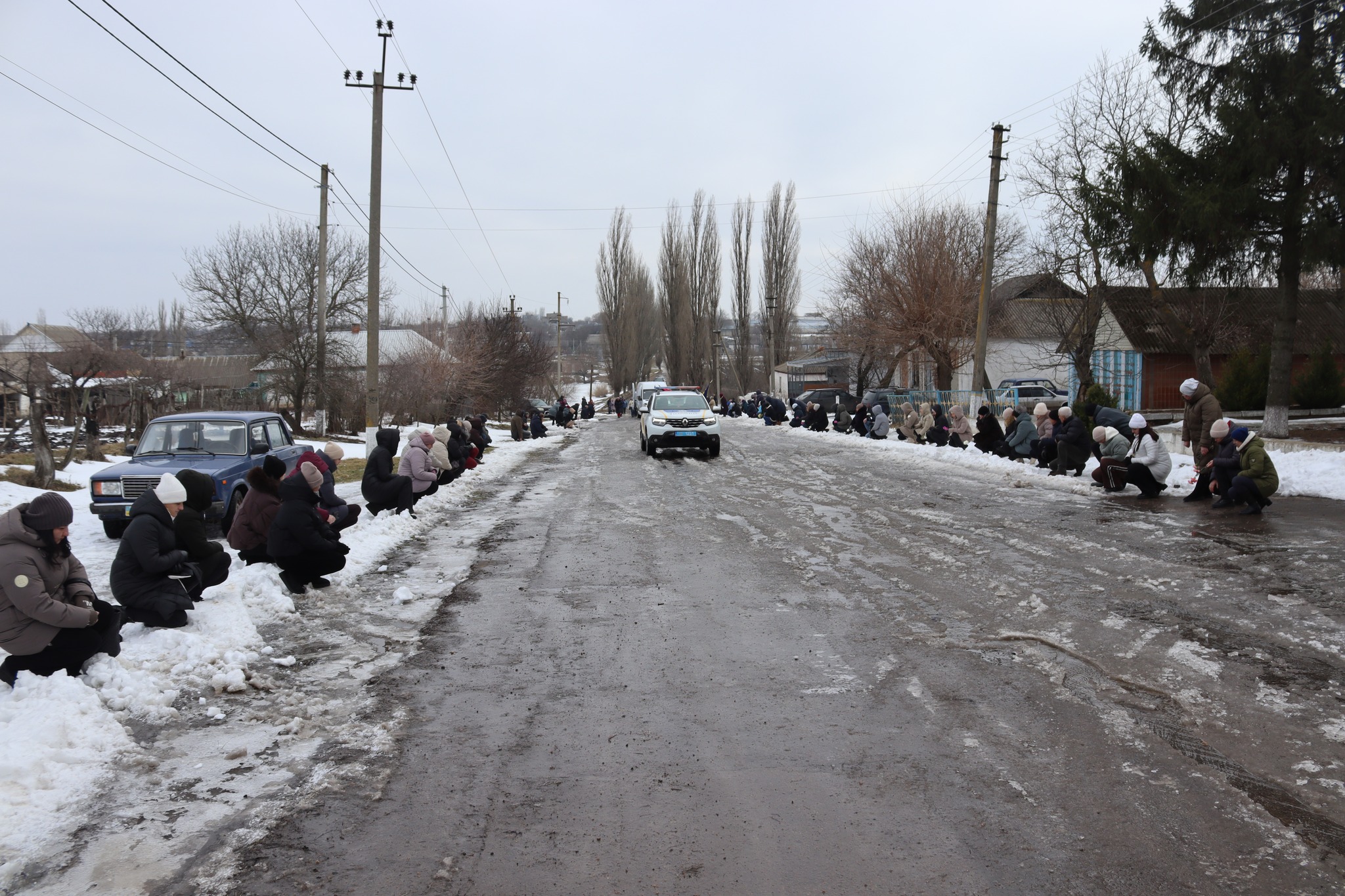 Поліцейська машина їде попереду ритуального кортежа загиблого Олега Загороднюка з Добровеличківської громади