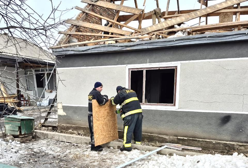 Рятувальники вставляють фанеру у вибите віно 