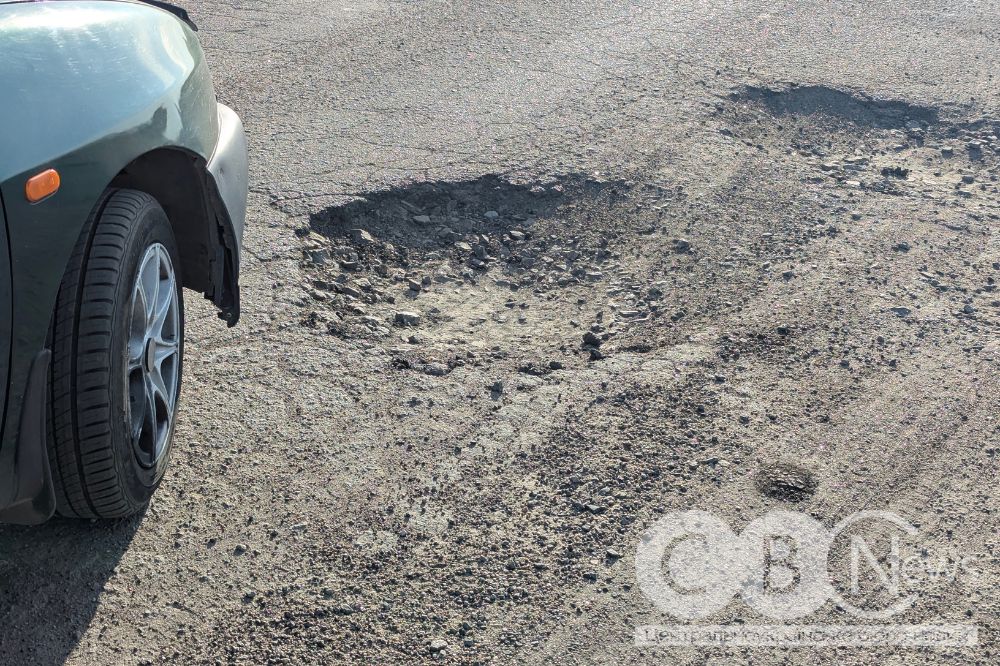 Колесо автівки біля вибоїни на дорозі