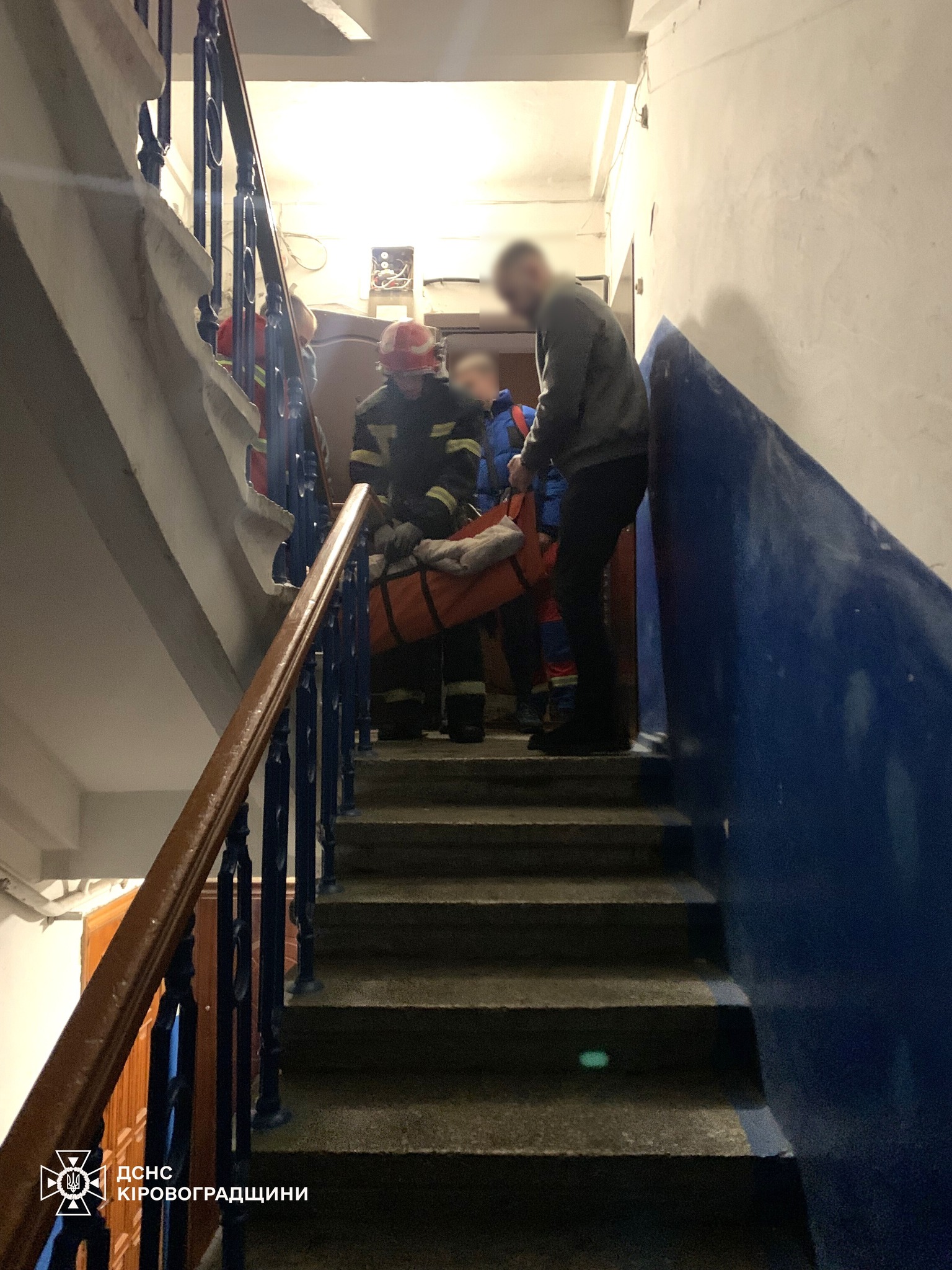 Рятувальники несуть по сходах жінку, якій стало зле, в Кропивницькому