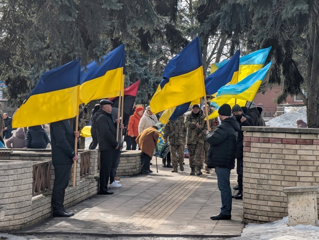 Люди з прапорами зустрічають похоронну процесію в Знам'янській громаді