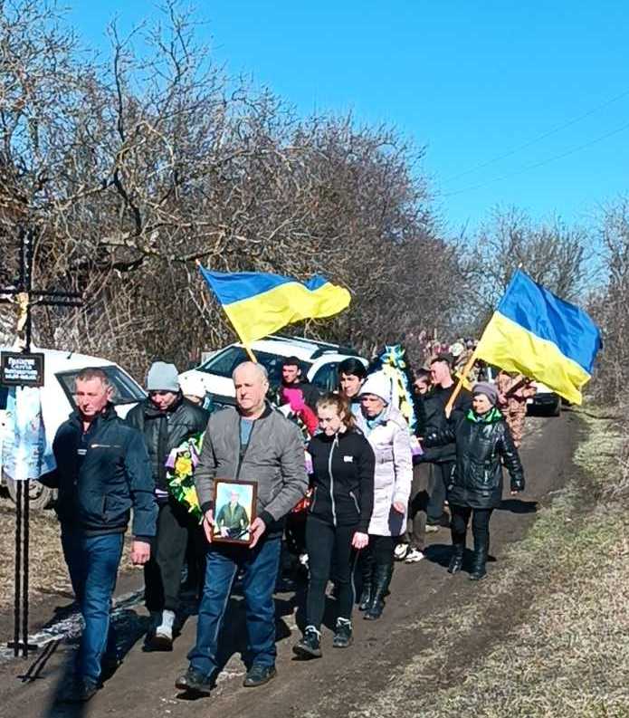 Люди несуть намогильний хрест та супроводжують траурний кортеж на прощанні із загиблим Сергієм Поліщуком з Олександрівської громади