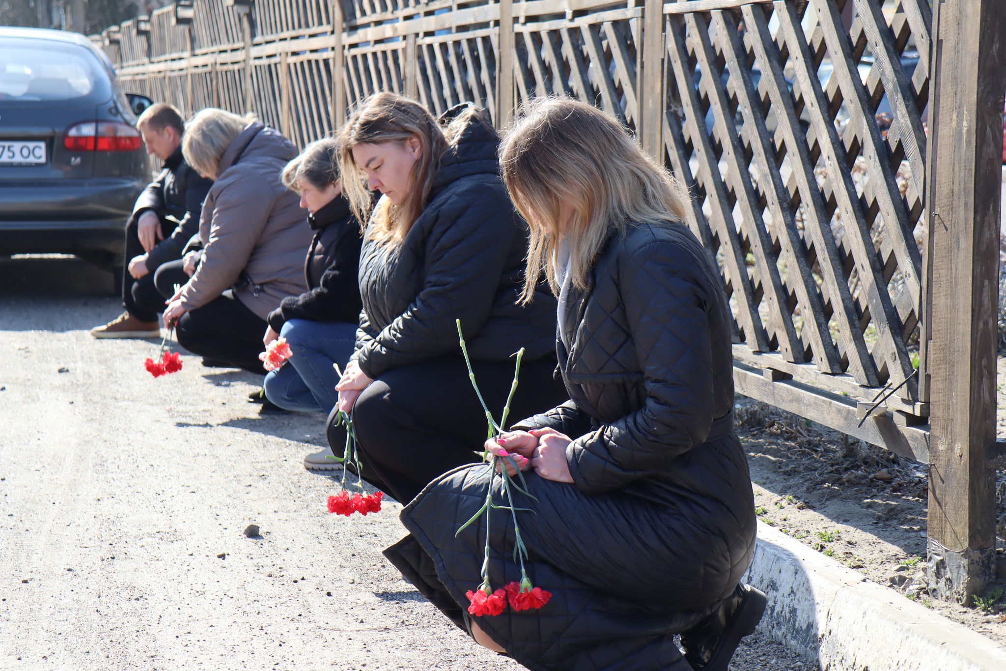 Люди з квітами на колінах проводжають в останню путь загиблого Дмитра Гарусова