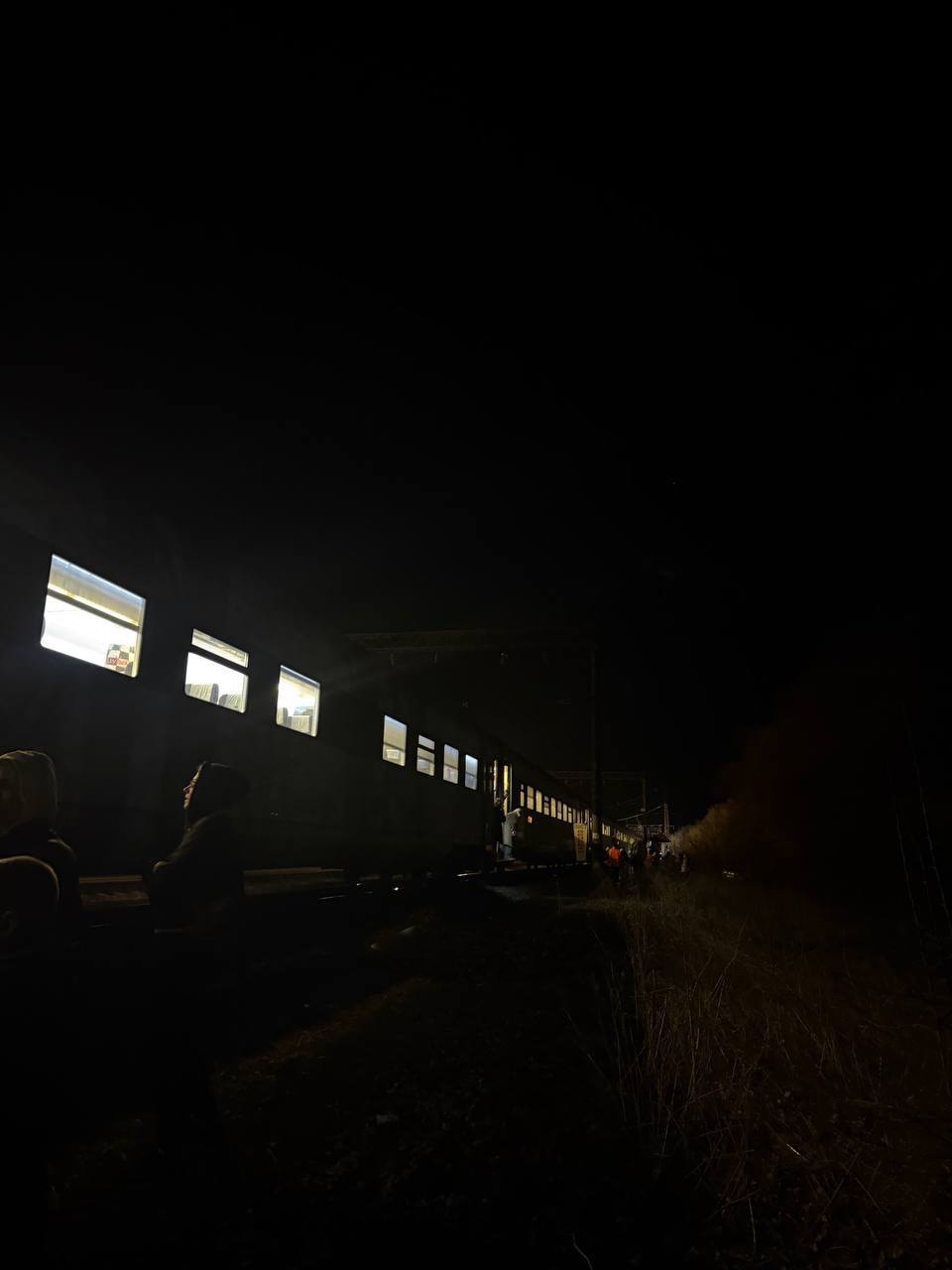 Люди стоять біля поїзда