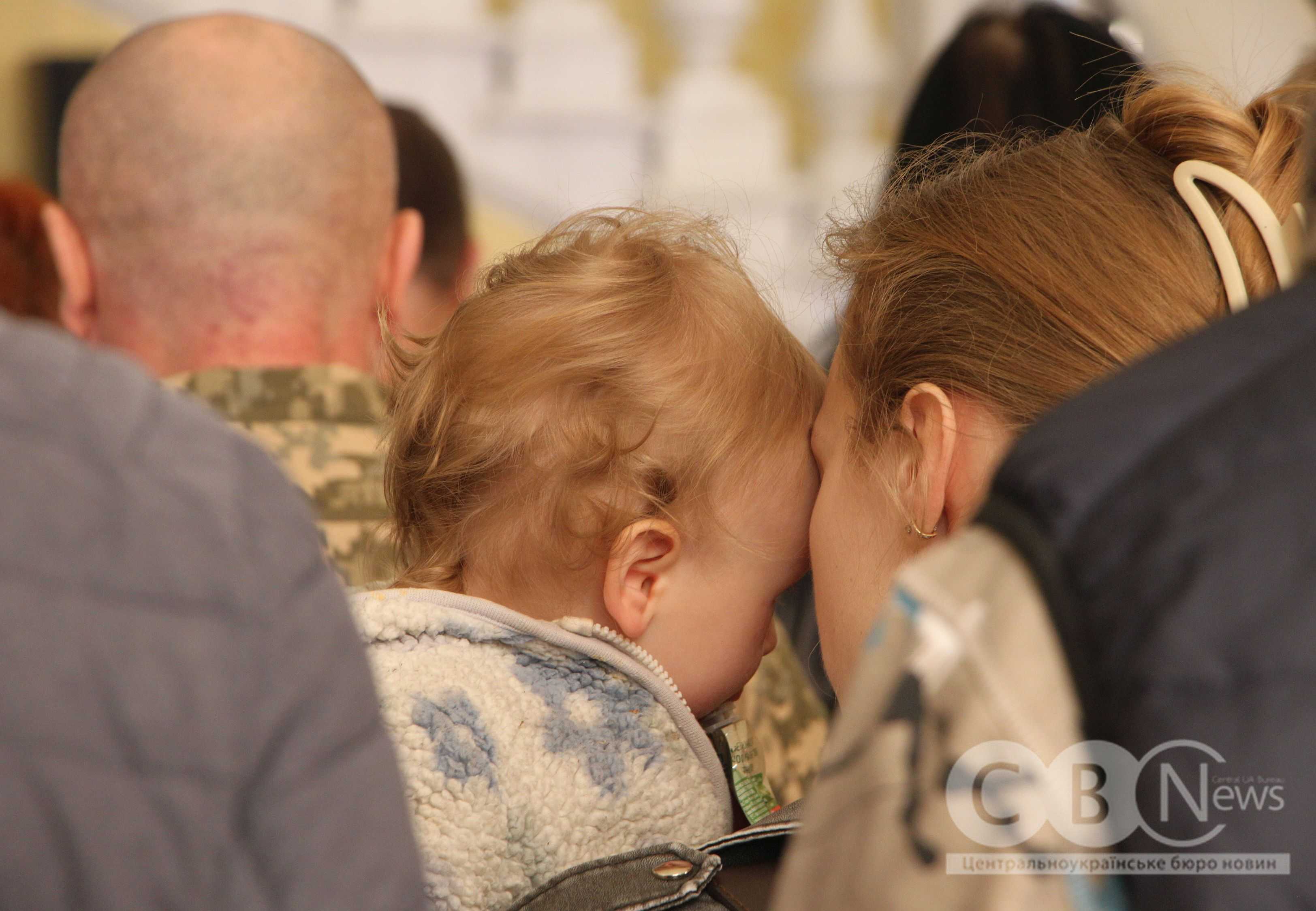 Мама з дитиною сидять у філармонії під час нагородження військових та ветеранів