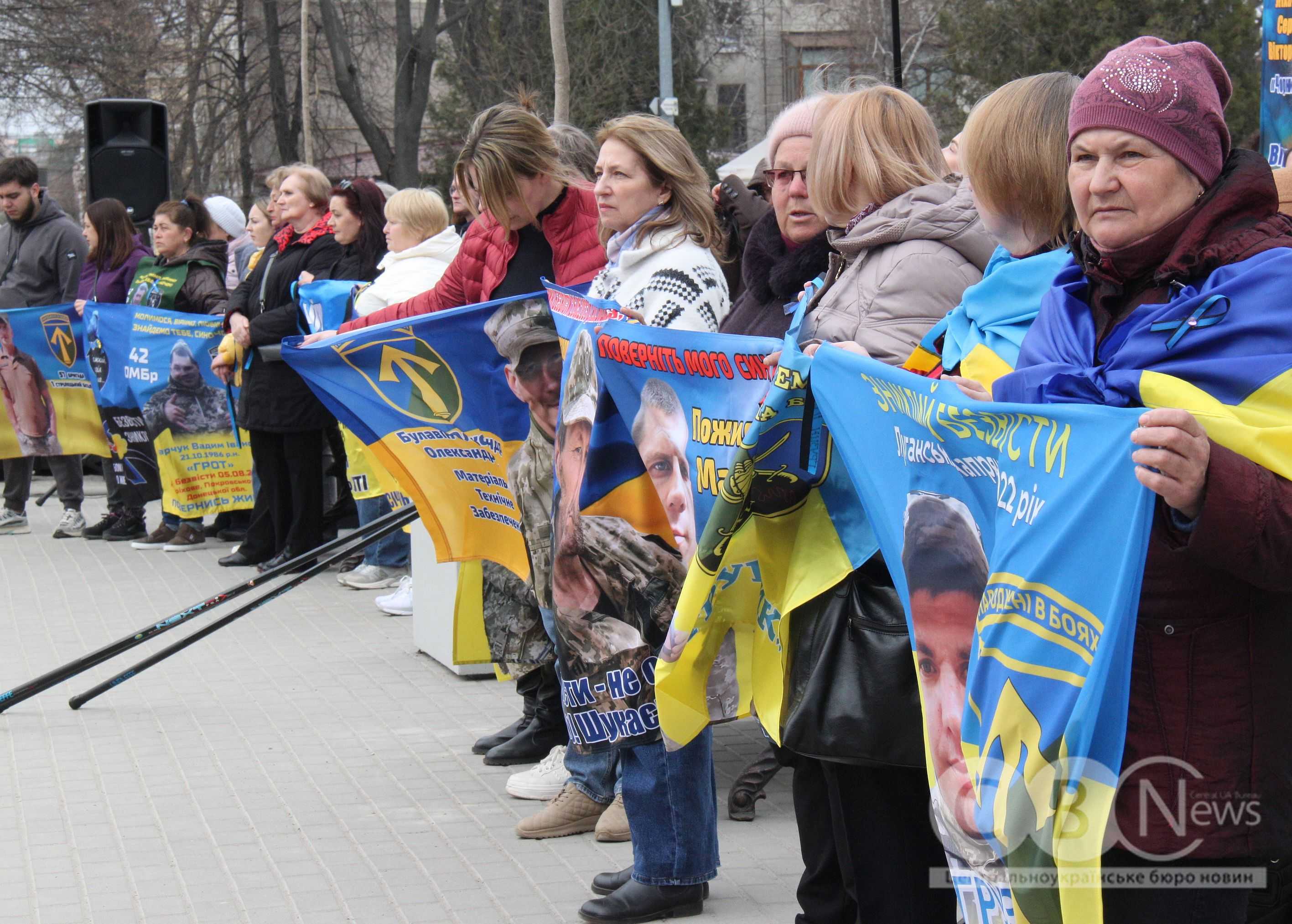 Люди стоять з прапорами на відкритті інсталяції