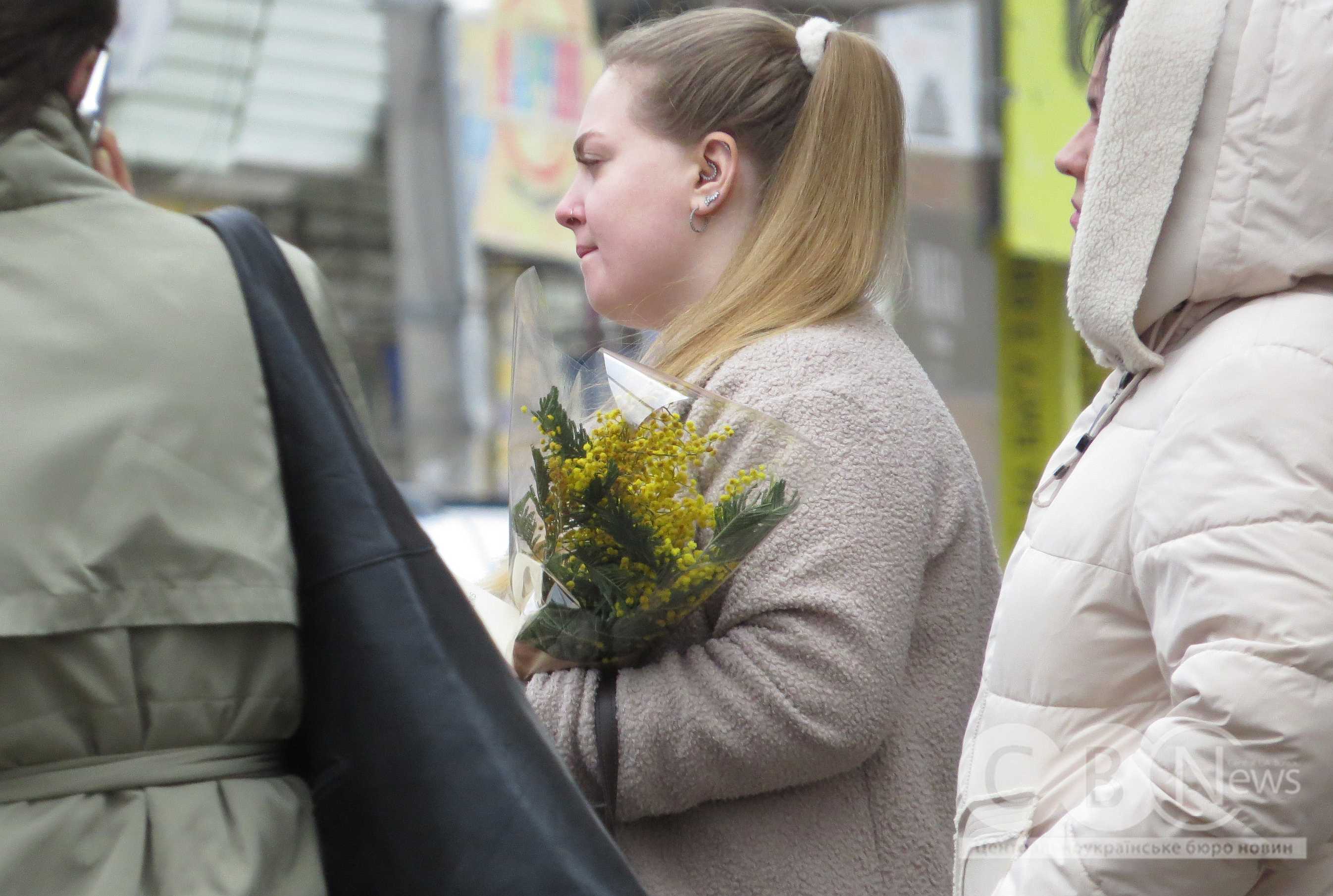 Жінка несе в руках квіти в середмісті Кропивницького