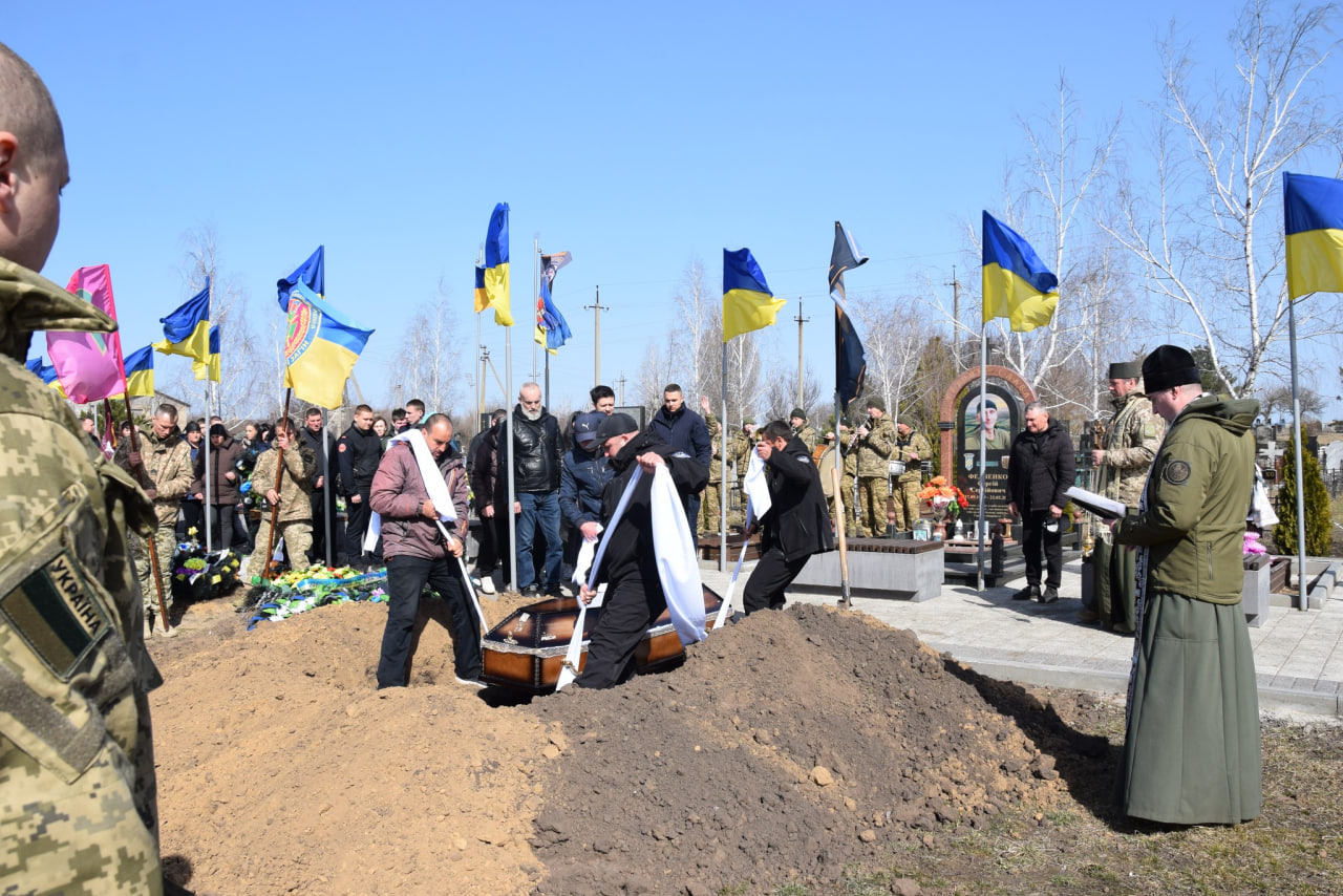 Трунарі опускають труну із загиблим військовим