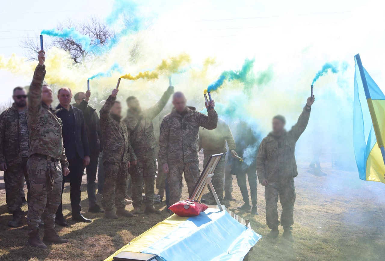 Військові тримають жовто блакитні димові шашки на прощанні