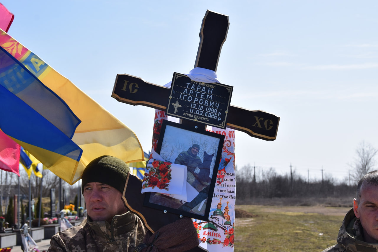 Чоловік тримає хрест з портретом Артема Тарана 