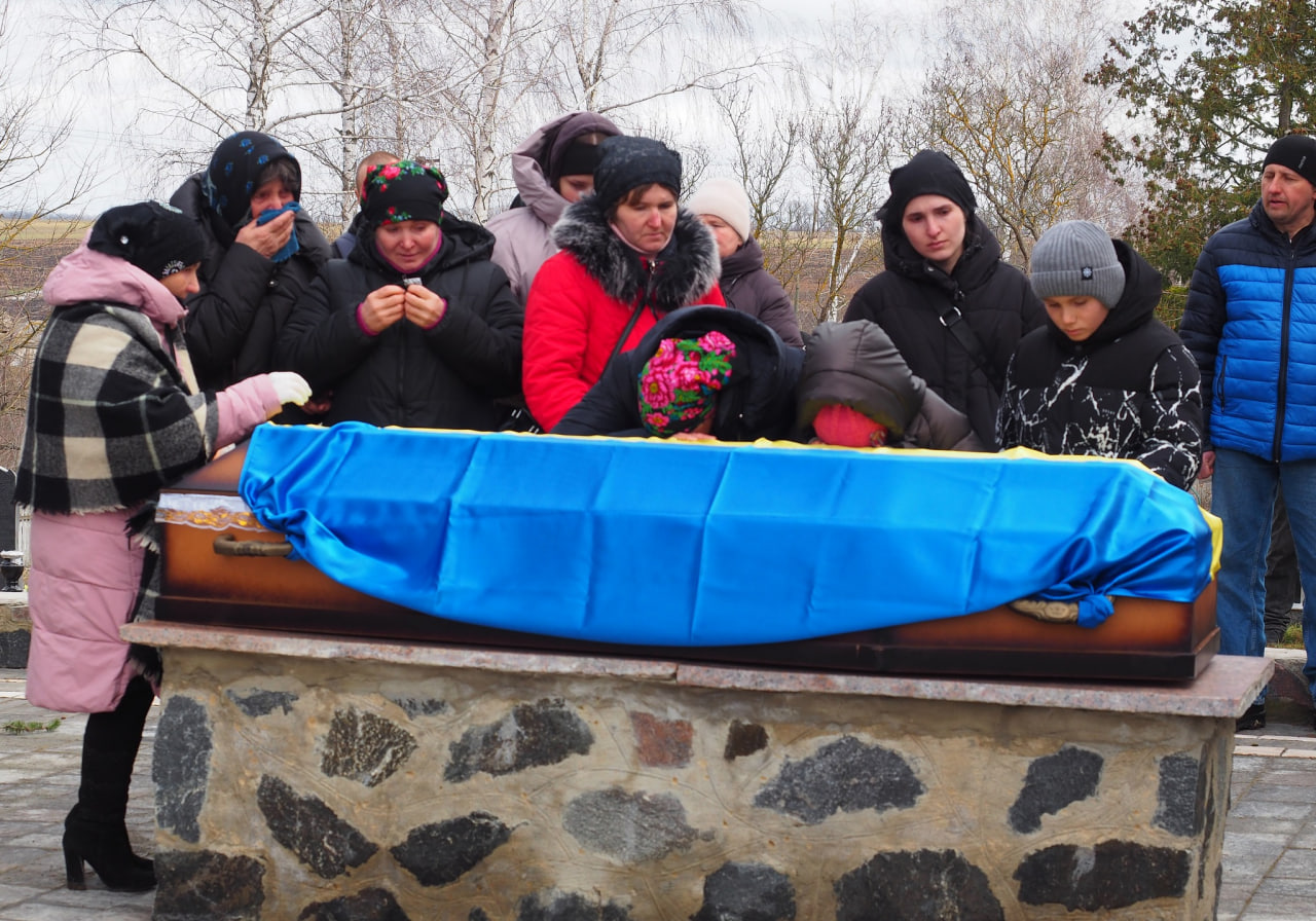 Люди біля труни на прощанні із загиблим військовим у Гайворонській громаді
