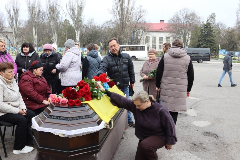 Жінка кладе квіти на труну загиблого Михайла Гапона