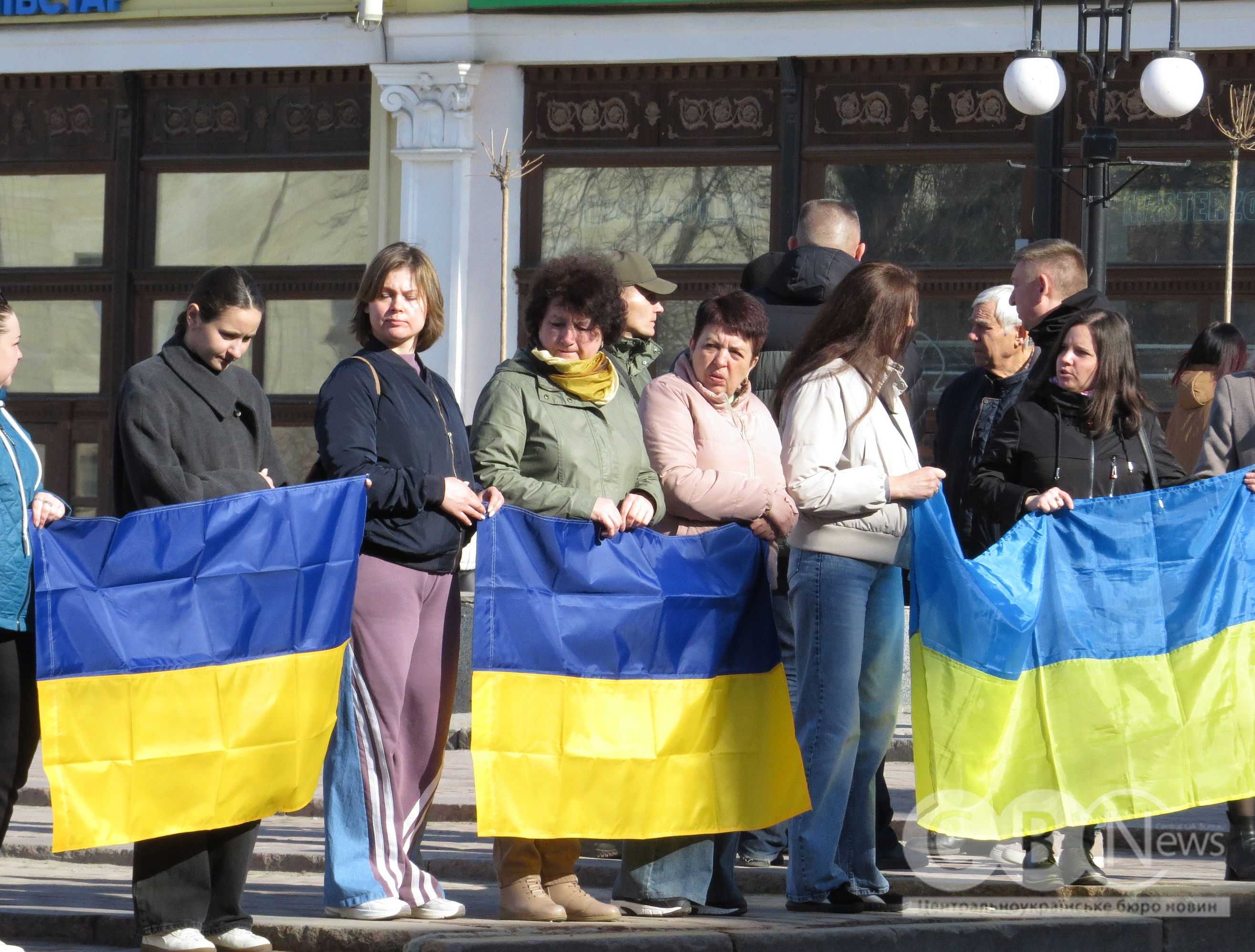 Люди стоять з прапорами на прощанні у Кропивницькому