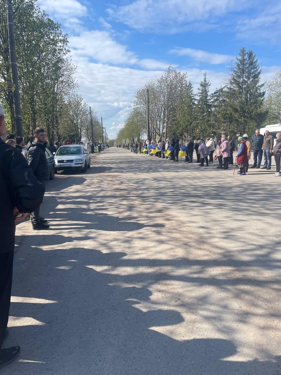 Люди з прапорами зустрічають траурний кортеж загиблого Сергія Рябоштана