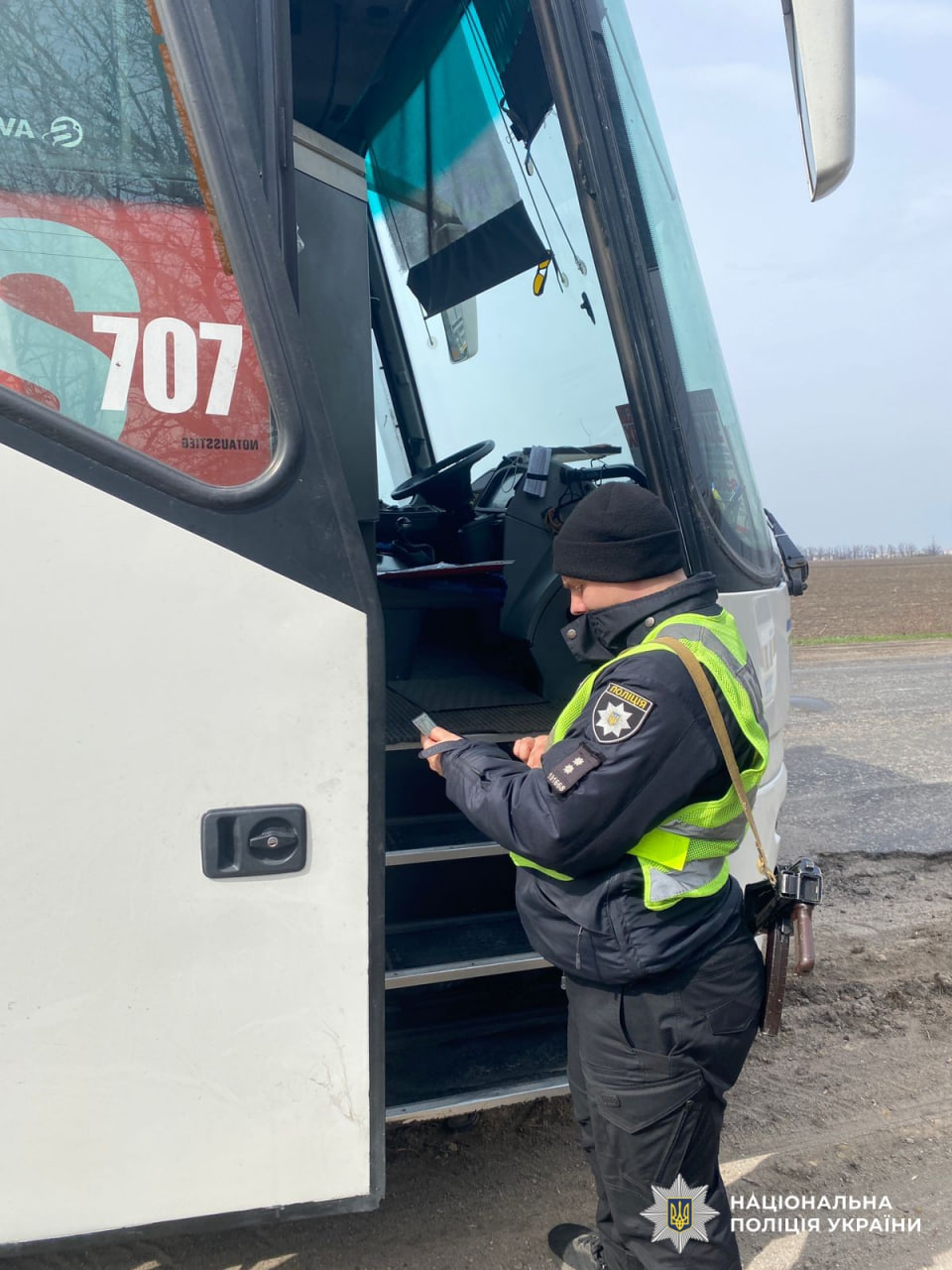 Патрульний перевіряє документи у водія автобуса