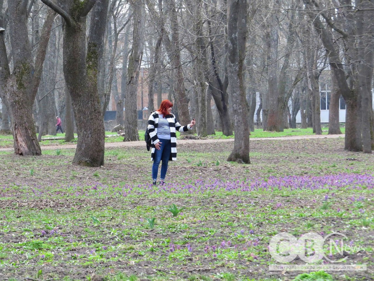 Жінка фотографує квіти в Дендропарку