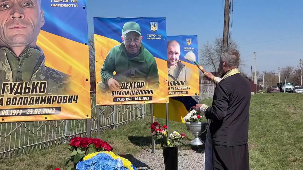 Священник освячує портрети загиблих воїнів з Новомиргородської громади