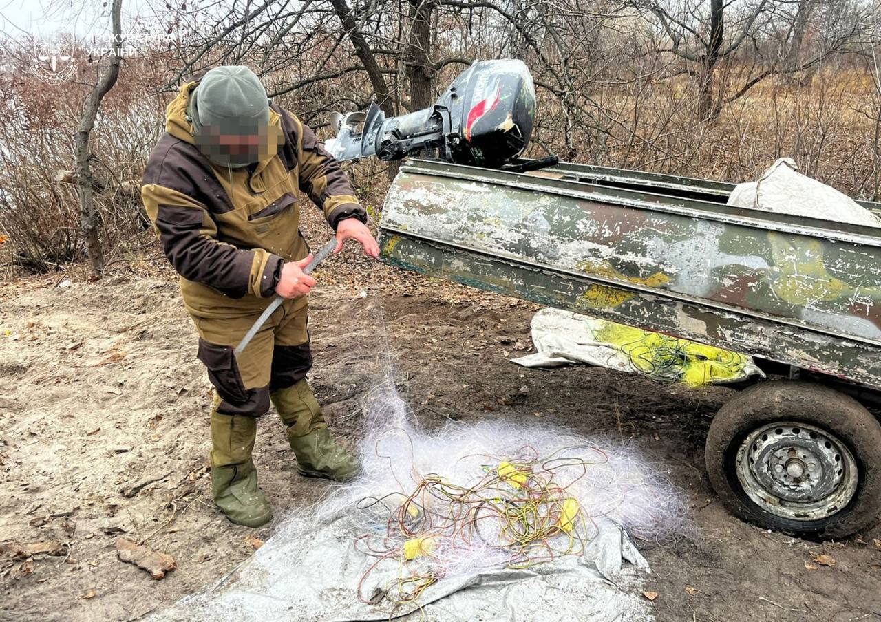 Чоловік тримає сітку, якою браконьєр ловив рибу