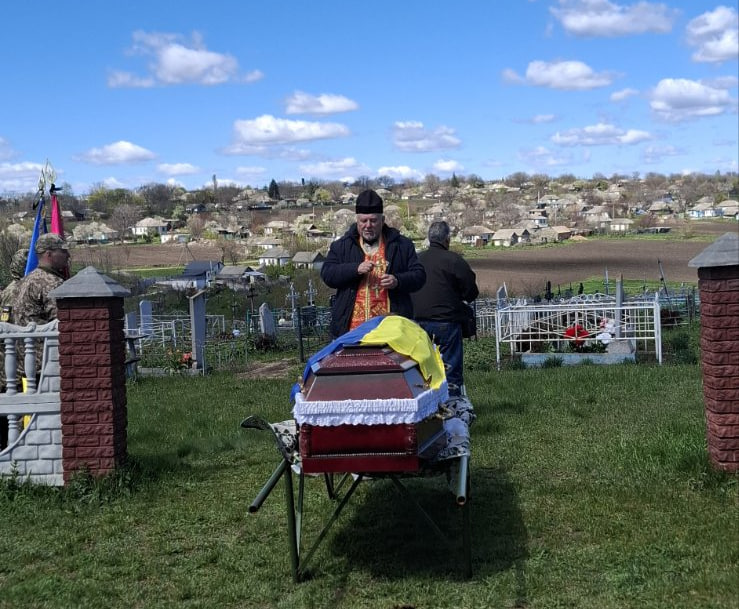 Священний проводить службу на прощанні із полеглим військовим Владиславом Гудаліним