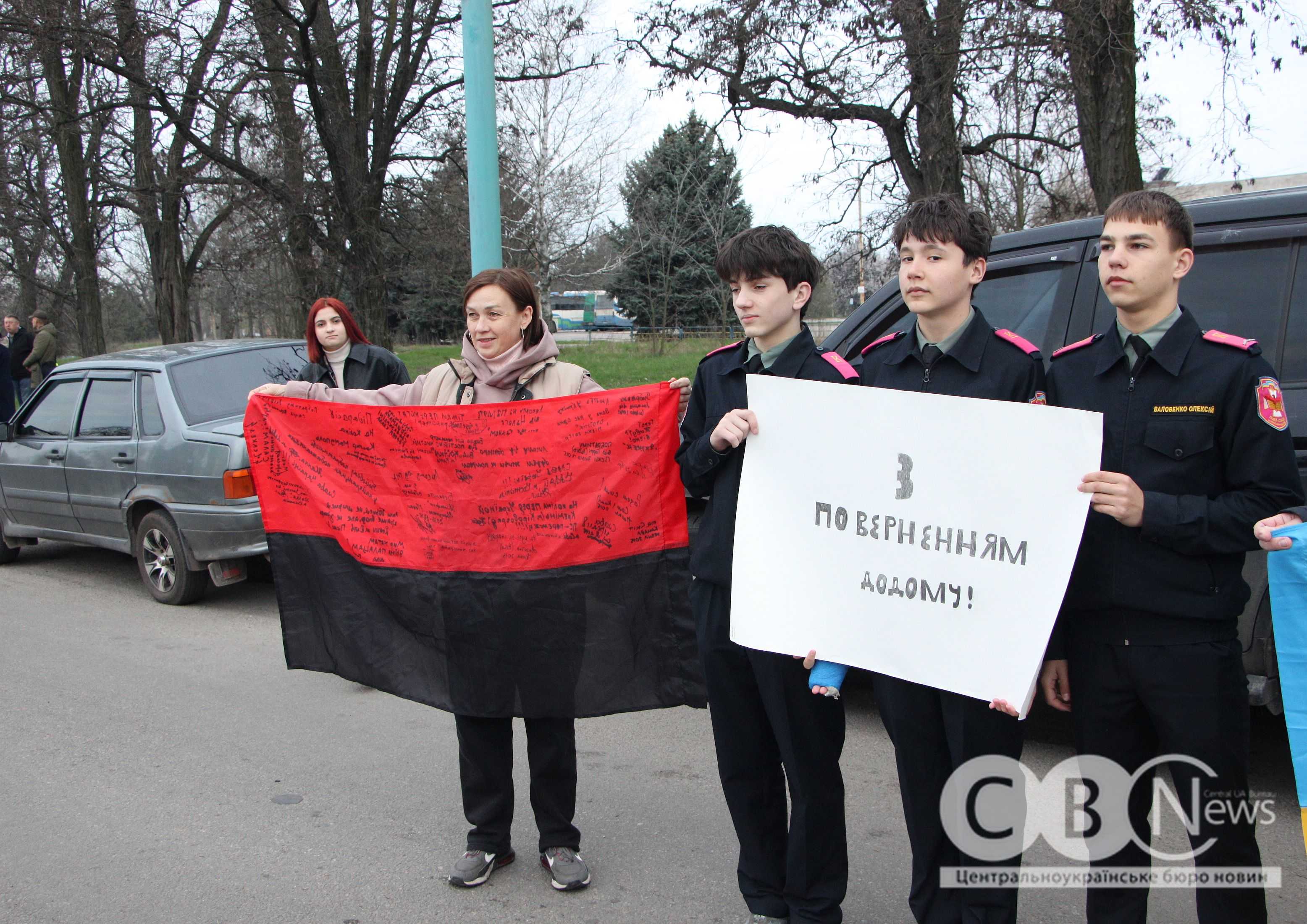 Містяни тримають прапори та плакати, зустрічаючи Євгена Коденця