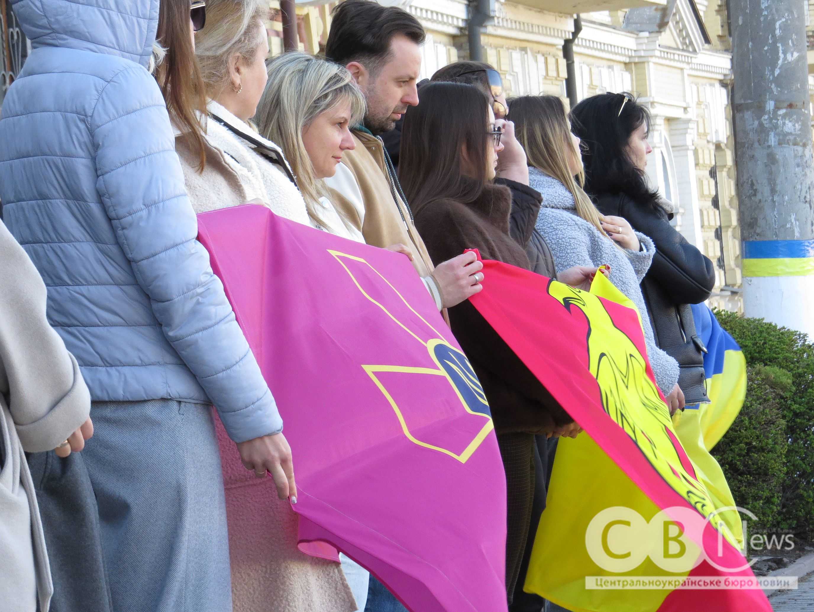 Кропивничани стоять у середмісті з прапорами під час прощання з воїном