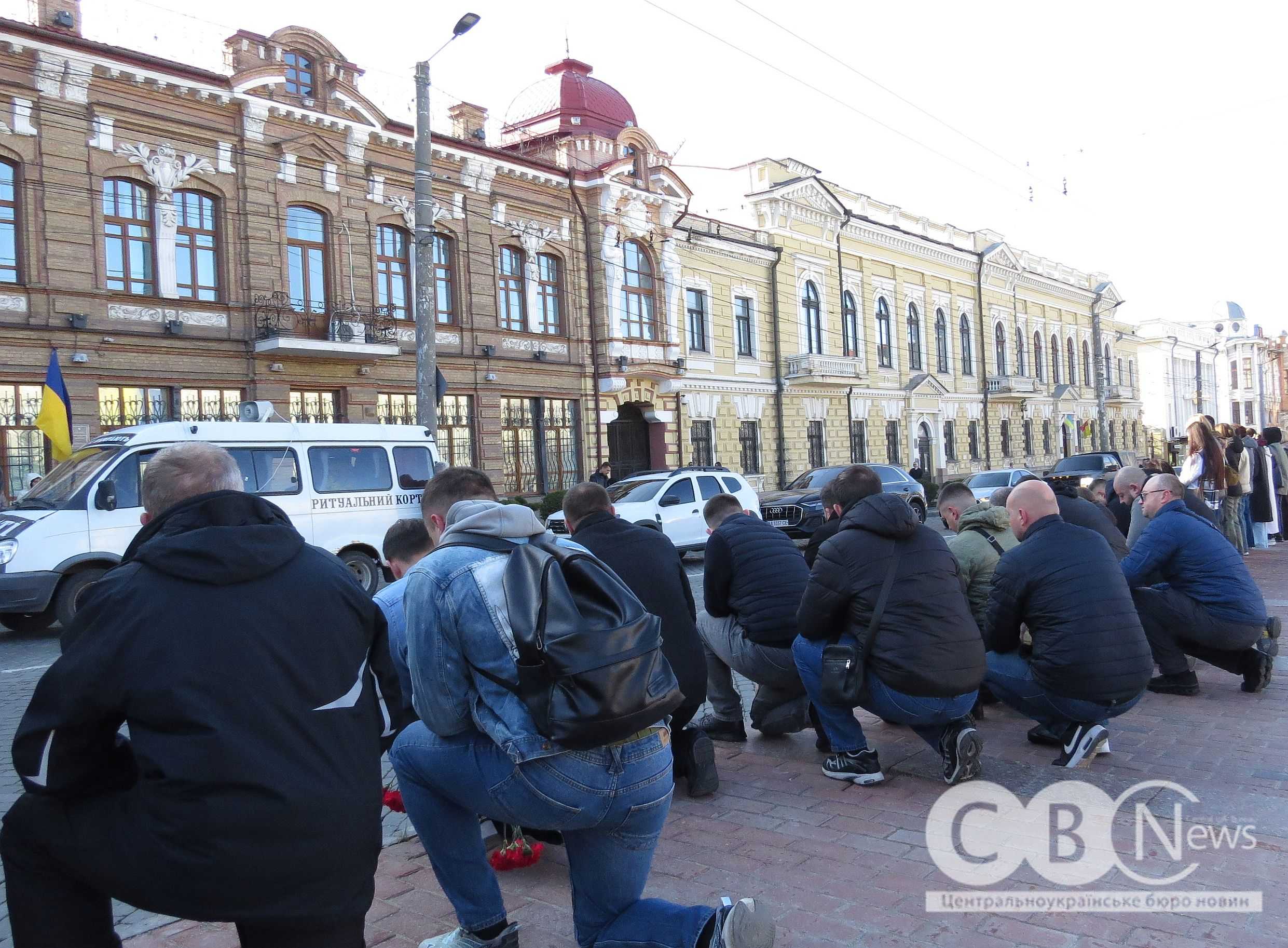 Кропивничани стоять на колінах під час прощання з воїном