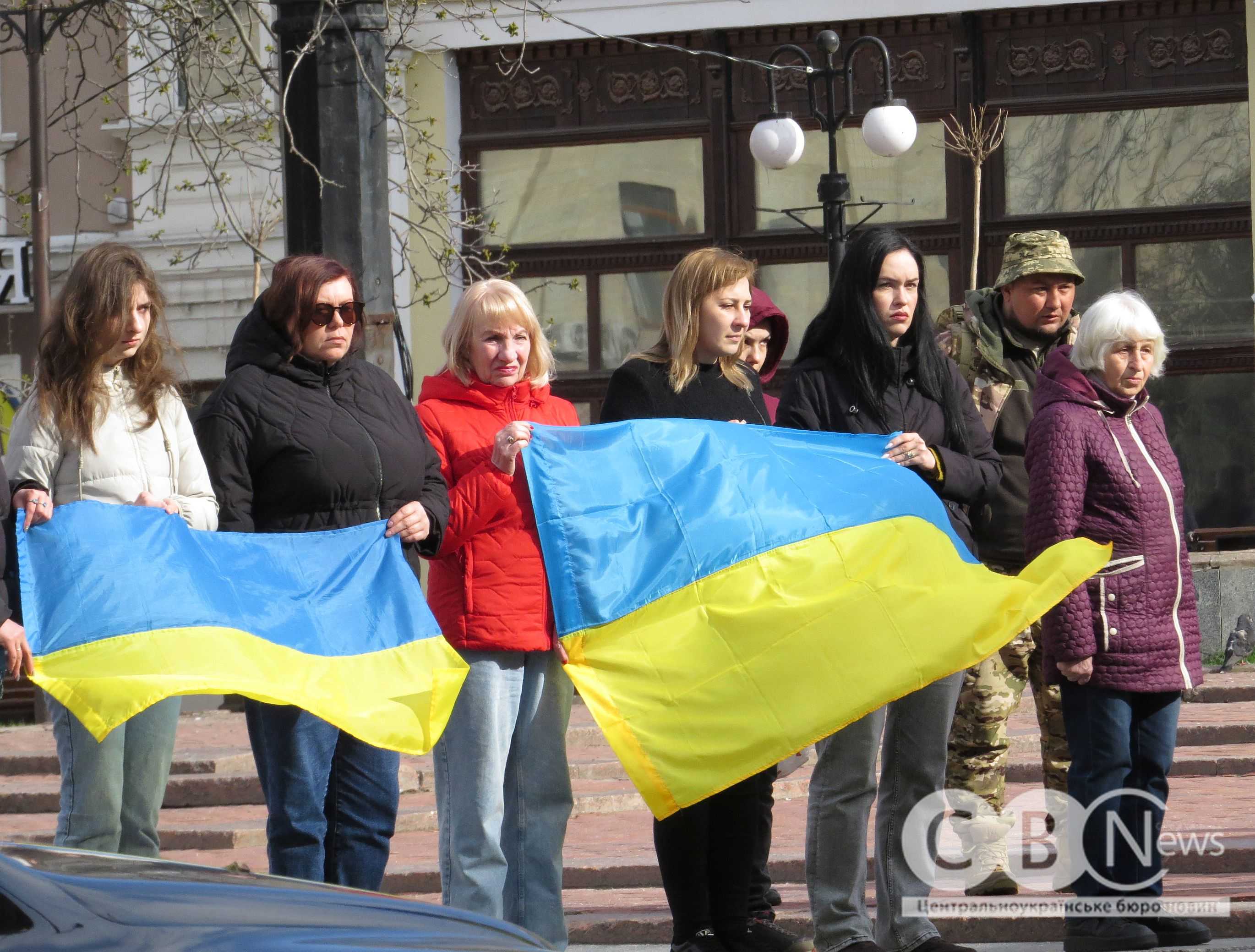 Люди стоять з прапорами під час прощання з воїнами з Кропивницького