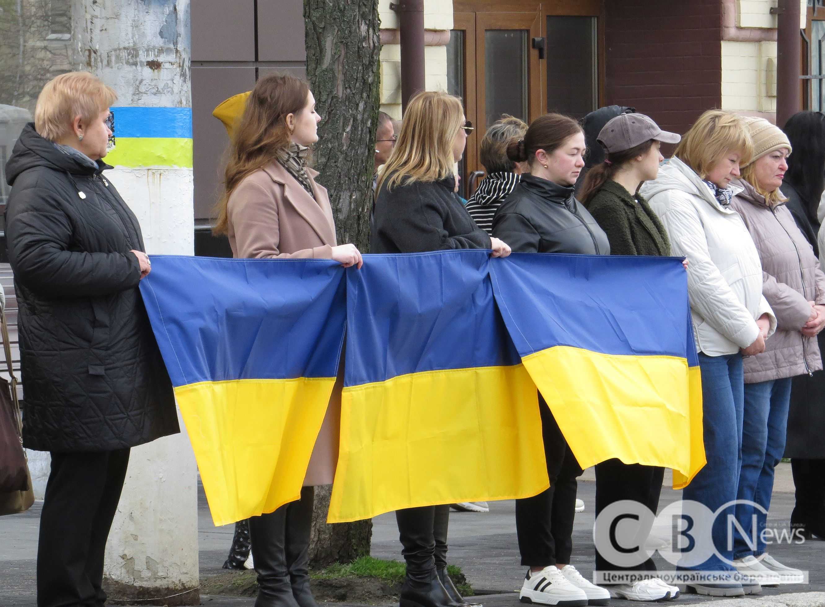 Люди стоять з прапорами під час прощання з воїнами з Кропивницького
