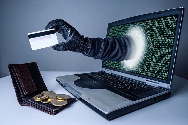 The abstract image of the hacker's hand reach through a laptop screen for stealing credit card in a wallet. the concept of cyber attack, virus, malware, illegally and cyber security.